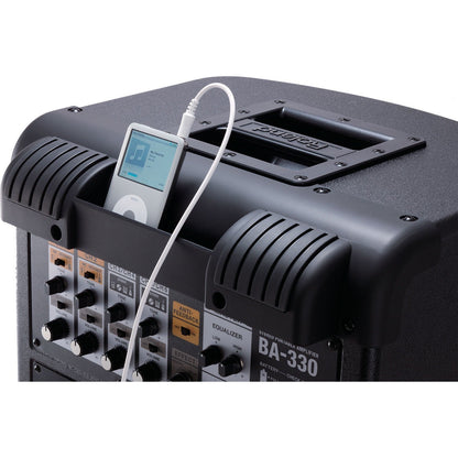 Sort Roland BA-330 forstærker med musikafspiller tilsluttet frontpanel og kontrolknapper.