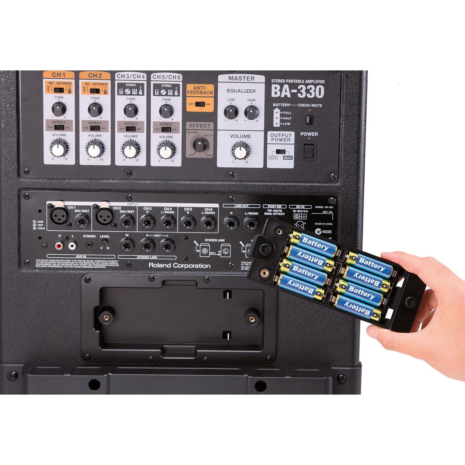 Person der indsætter batterier i Roland BA-330 lydanlæg med kontrolpanel og stikbaggrund