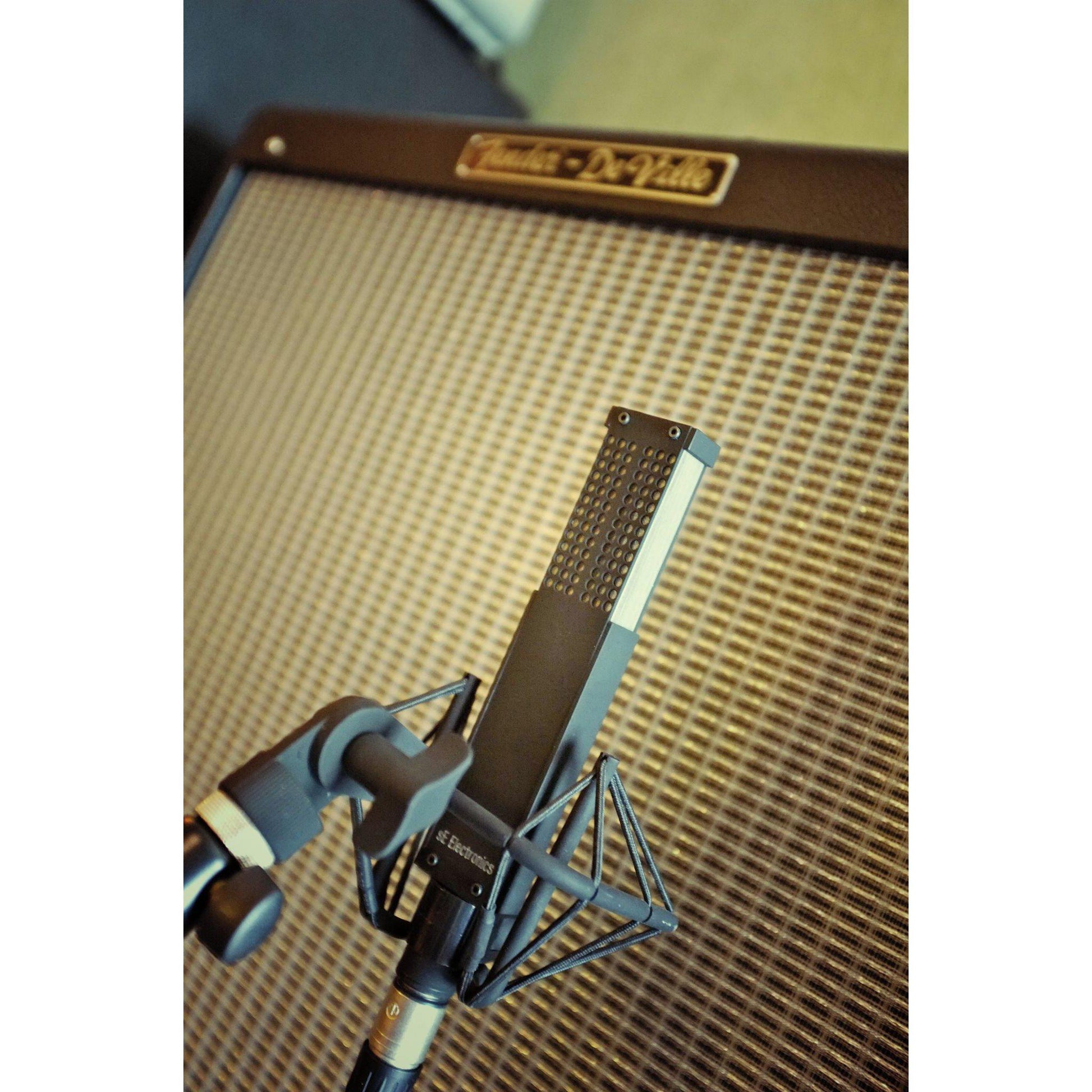 studio mikrofon monteret foran guitarforstærker med fokus på detaljer og klarhed
